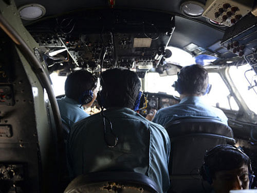Vietnamese Air Force officers sit in the cockpit of a search and rescue aircraft as they fly over the search area for a missing Malaysia Airlines plane, 250 km from Vietnam and 190 km from Malaysia, March 9, 2014. Malaysia Airlines said it was 'fearing the worst' on Sunday for a plane carrying 239 people that went missing more than 24 hours ago, as the government said it was investigating four passengers who may have held false identity documents. REUTERS