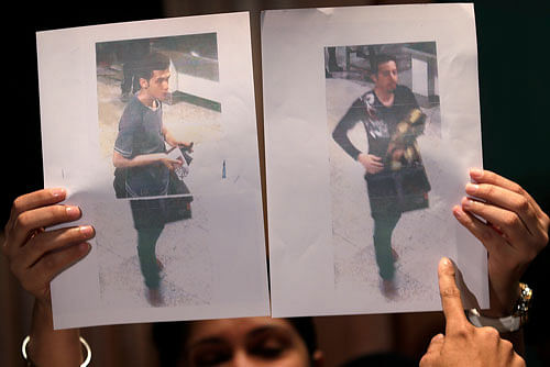 Pictures of the two men, a 19-year old Iranian, identified by Malaysian police as Pouria Nour Mohammad Mehrdad, left, and the man on the right, his identity still not released, who boarded the now missing Malaysia Airlines jet MH370 with stolen passports, is held up by a Malaysian policewoman during a press conference, Tuesday, March 11, 2014 in Sepang, Malaysia. One of the two men traveling on a missing Malaysian Airlines jetliner was an Iranian asylum seeker, officials said Tuesday, as baffled authorities expanded their search for the Boeing 777 on the opposite side of the country from where it disappeared nearly four days ago with 239 people on board. AP