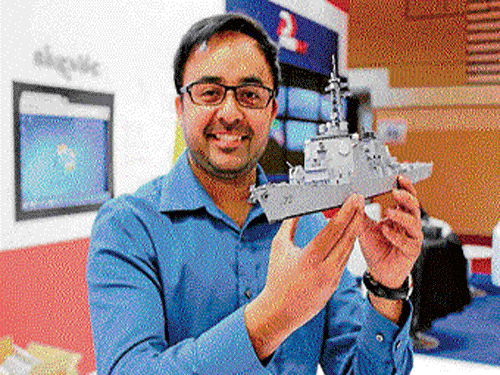 Atamjeet poses with his paper model of a ship.