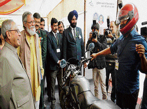 Jitendra Sahu shows President Pranab Mukherjee a bike which can be driven  only by a helmet-wearing driver, March 13, 2014, DHNS