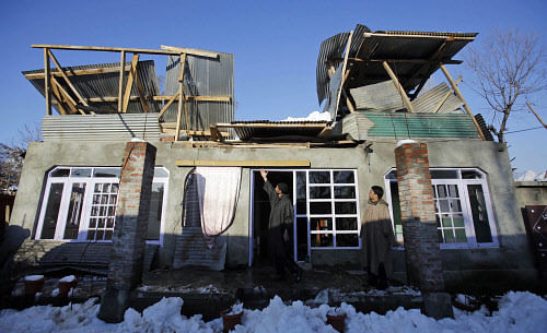 A Kashmiri man points to the roof of his house damaged under the weight of snow in Srinagar on Wednesday. PTI Photo