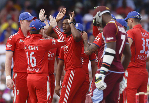 England's Chris Jordan, third from right, celebrates with teammates the dismissal of West Indies' Marlon Samuels during their third T20 International cricket match at the Kensington Oval in Bridgetown, Barbados, Thursday, March 13, 2014. (AP Photo)