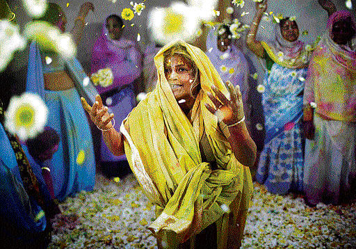 A widow throws flowers during Holi celebrations at a  widows' ashram in Vrindavan on Friday. REUTERS