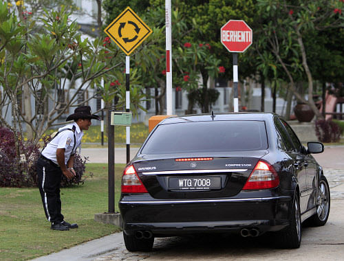 A security guard checks a car at a main gate of the missing Malaysia Airlines pilot Zaharie Ahmad Shah's house in Shah Alam, outside Kuala Lumpur, Malaysia, Saturday, March 15, 2014. Malaysian police have already said they are looking at the psychological state, the family life and connections of pilot Zaharie, 53, and co-pilot Fariq Abdul Hamid, 27. Both have been described as respectable, community-minded men. The Malaysian jetliner missing for more than a week had its communications deliberately disabled and its last signal came about 7 1/2 hours after takeoff, meaning it could have ended up as far as Kazakhstan or into the southern reaches of the Indian Ocean, Malaysian Prime Minister Najib Razak said Saturday. (AP Photo)