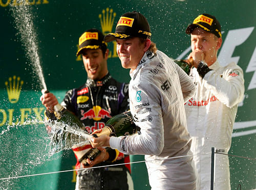 Winner Mercedes Formula One driver Nico Rosberg of Germany (C) sprays champagne beside second-placed Red Bull Formula One driver Daniel Ricciardo of Australia (L) and third-placed McLaren Formula One driver Kevin Magnussen of Denmark after the Australian F1 Grand Prix at the Albert Park circuit in Melbourne, Reuters