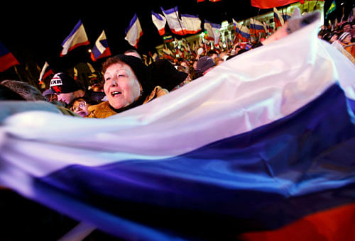 today's referendum on Lenin Square in the Crimean capital of Simferopol A woman waves a Russian flag as people wait for the announcement of preliminary results of today's referendum on Lenin Square in the Crimean capital of Simferopol March 16, 2014. Crimeans voted in a referendum on Sunday on whether to break away from Ukraine and join Russia, with Kiev accusing Moscow of pouring forces into the peninsula and warning separatist leaders 'the ground will burn under their feet'. REUTERS