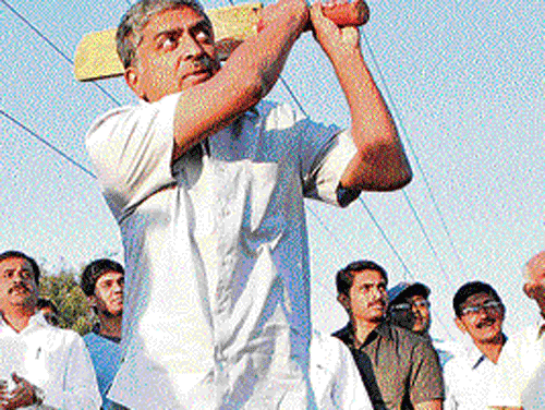 Congress candidate Nandan Nilekani plays cricket during his campaign in the City on Sunday. KPN