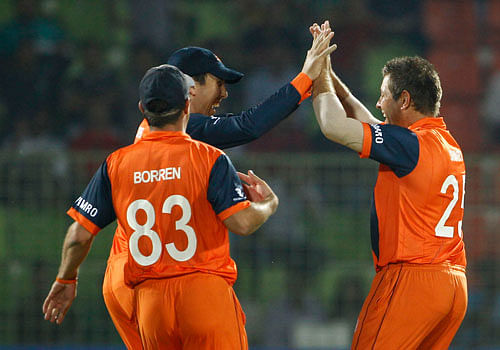 Netherlands bowler Michael Swart, right, celebrates with his teammates taking the wicket of United Arab Emirates's Faizan Asif during their ICC Twenty20 Cricket World Cup match in Sylhet, Bangladesh, Monday, March 17, 2014. AP