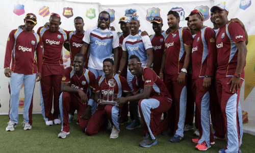 The West Indies cricket team poses with the trophy after beating England 2-1, in the series of three T20 International cricket matches at the Kensington Oval in Bridgetown, AP