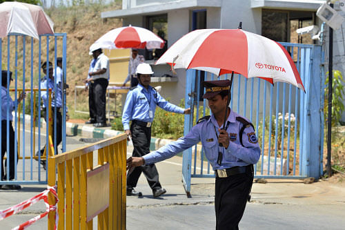 A private security guard moves a barricade outside a closed plant of Toyota Motor Corp's India unit near Bangalore. Reuters.