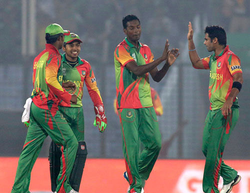 Bangladesh's Al-Amin Hossain, center, celebrates with teammates the fall of Nepalese wicket during their ICC Twenty20 Cricket World Cup match in Chittagong, Bangladesh, Tuesday, March 18, 2014. AP