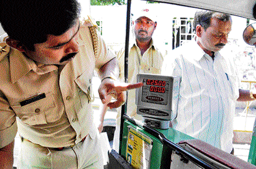 An official of Legal Metrology Department inspects an  autorickshaw meter at Yeshwantpur on Tuesday. DH PHOTO