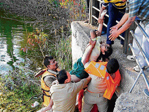 Rescue personnel recover the body of one of the girls. dh photos