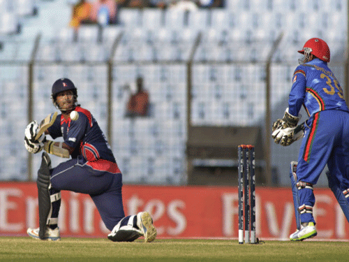 Nepal's Subash Khakurel plays a shot as Afghanistan's wicketkeeper Mohammad Shahzad, right, watches during their ICC Twenty20 Cricket World Cup match. AP Photo