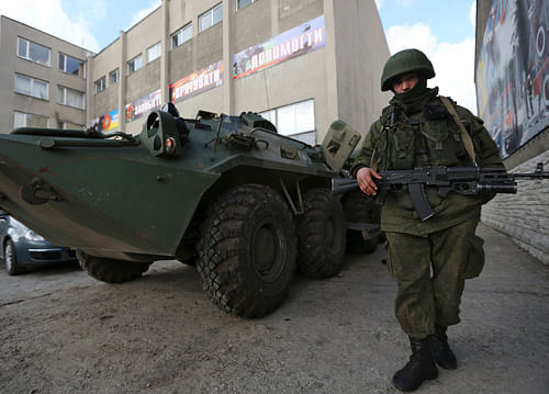 A soldier in an unmarked uniform stands guard at APC outside the Ukrainian Military Prosecutor's Office in Simferopol, Crimea, Thursday, March 20, 2014.  India is in touch with the authorities at Crimea State Medical University to ensure security of Indian students pursuing their studies at the institution. AP