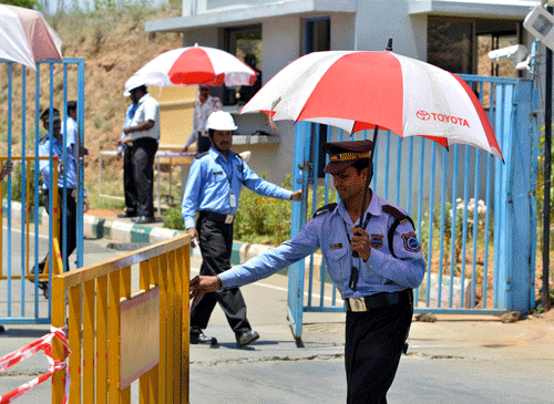 A private security guard moves a barricade outside a closed plant of Toyota Motor Corp's India unit near Bangalore March 18, 2014. The unit has temporarily closed its two plants where some workers had stopped production lines to protest a delay in salary hikes after 10 months of negotiations. The factories near Bangalore are Toyota Motor's only vehicle plants in the world's sixth-biggest auto market, where the Japanese manufacturer generates just a sliver of global sales. REUTERS