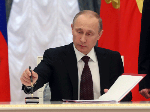 Russian President Vladimir Putin signs bills making Crimea part of Russia in the Kremlin in Moscow. Putin completed the annexation of Crimea on Friday, signing the peninsula into Russia at nearly the same time his Ukrainian counterpart sealed a deal pulling his country closer into Europe's orbit. AP Photo