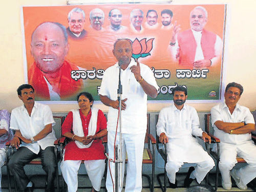 Hassan Lok Sabha constituency BJP candidate C H Vijayashankar speaks at a BJP workers meeting in Kadur on Sunday. Former MP Tejaswini,  MLA C T Ravi among others look on. DHNS