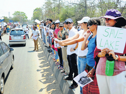 Residents stage a protest opposing the proposed construction of a  shopping mall on the wetland of Bellandur Lake, in City on Sunday. DH photo