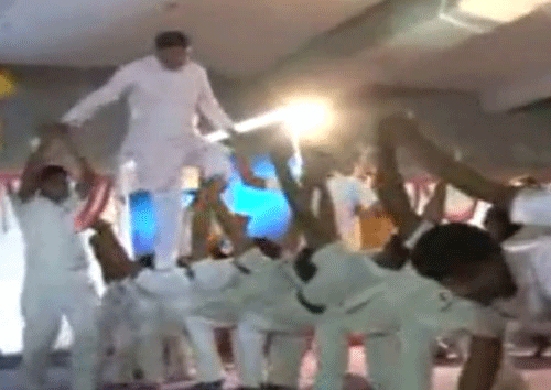 TV screen grab of video showing BJP Lok Sabha nominee Mohan Kundariya walking on the backs of students.