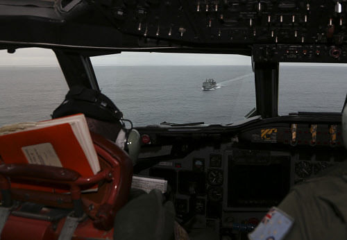 Flight Lt. Jason Nichols on board a Royal Australian Air Force AP-3C Orion, looks towards HMAS Success as they search over the southern Indian Ocean for missing Malaysia Airlines flight MH370 in Southern Indian Ocean, Australia, Saturday, March 22, 2014. AP