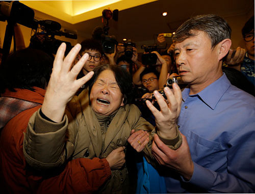 A family member of a passenger aboard Malaysia Airlines MH370 cries as she is surrounded by journalists after watching a television broadcast of a news conference, at the Lido hotel in Beijing, March 24, 2014. Relatives of Chinese passengers aboard the missing Malaysia Airlines flight reacted with hysteria on Monday after the Malaysian prime minister announced the jet ended its journey in the remote Southern Indian Ocean. REUTERS