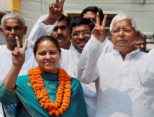 RJD chief Lalu Prasad along with his daughter and party candidate from Patliputra Misa Bharti and supporters wave victory sign after Bharti filed her nomination papers in Patna on Tuesday. Daughter's love forced RJD chief Lalu Prasad to bargain with jailed gangster Ritlal Yadav to get his support for Misa Bharti and appoint him the party general secretary. PTI Photo