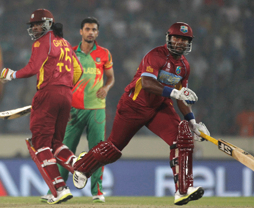 West Indies' Chris Gayle (L) and Dwayne Smith run between the wickets as Bangladesh's bowler Mashrafe Mortaza (C) looks on during their ICC Twenty20 World Cup match at the Sher-E-Bangla National Cricket Stadium in Dhaka March 25, 2014. REUTERS