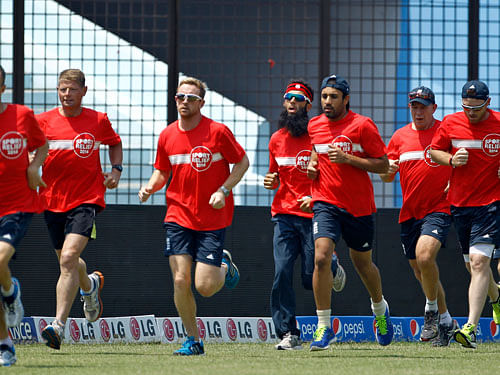 England's cricket team members and officials warm up during a training session ahead of their ICC Twenty20 Cricket World Cup match against Sri Lanka in Chittagong, Bangladesh, Sunday, March 23, 2014. (AP Photo/A.M. Ahad)