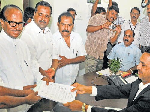 Congress candidate B Janardhan Poojary submits his nomination papers to Returning Officer A&#8200;B&#8200;Ibrahim as District-in-Charge Minister B&#8200;Ramanath Rai, Health Minister U&#8200;T&#8200;Khader and MLA&#8200;Vasanth Bangera look on. DH Photo