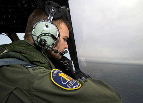 Royal Australian Air Force (RAAF) Flight Lieutenant Russell Adams looks out from the flight deck of a AP-3C Orion as he flies over the southern Indian Ocean, participating in the search for missing Malaysian Airlines flight MH370. Reuters Image