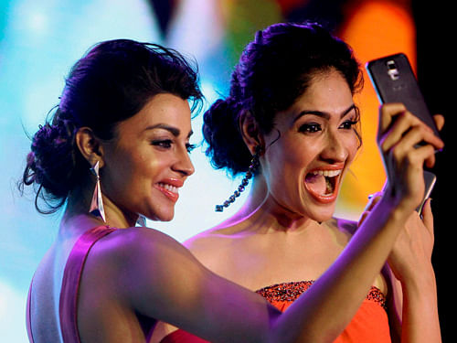 Models display Samsung Galaxy S5 smartphone during its launch in New Delhi on Thursday. PTI Photo