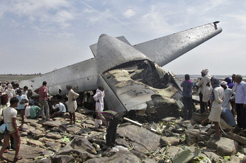 Onlookers stand next to the debris of a crashed U.S.-made C-130J Hercules aircraft of Indian Air Force (IAF) in the central Indian state of Madhya Pradesh March 28, 2014. The IAF cargo plane crashed on Friday, killing its crew of five, in the latest of a string of accidents to spotlight poor safety standards across the country's armed services. REUTERS