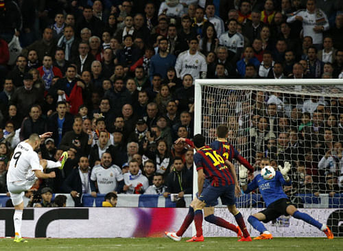 Karim Benzema of Real Madrid scores a goal against Barcelona goalkeeper Victor Valdes , Gerard Pique and Sergio Busquets during La Liga second Clasico soccer match of the season at Santiago Bernabeu stadium in Madrid, Reuters photo