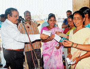 Deputy Commissioner Dr Muddumohan hands over pamphlets and appeals to fisherwomen to exercise their franchise, as a part of SVEEP programme at Malpe port on Saturday. DH photo