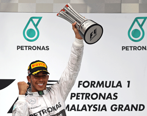 Mercedes driver Lewis Hamilton of Britain holds up his trophy after winning the Malaysian Formula One Grand Prix at Sepang International Circuit in Sepang, Malaysia, Sunday, March 30, 2014. (AP Photo/Lai Seng Sin)