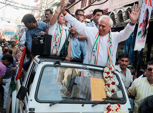 Congress candidate from Chandni Chowk Kapil Sibal waves to residents in the Walled City, in New Delhi on Tuesday. pti