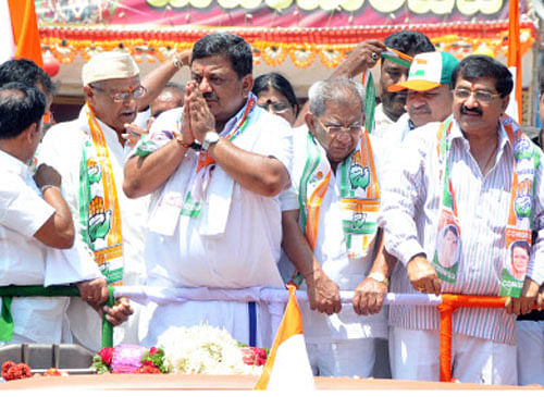 Congress candidate S.S. Mallikarjun waves at the party supporters during a rally in Davangere on Wednesday. His father and District-incharge Minister Shamanur Shivashankerappa, ex-MLA B.P. Harish, Abdul Jabbar and others were present. DH Photo.