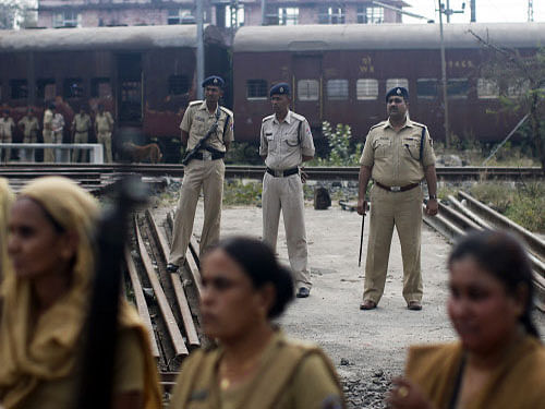 The Election Commission (EC) today removed objectionable posters on Godhra riots in the outer premises of the Patna airport and lodged FIR in the matter. Policemen stand guard near a train carriage, that was set on fire in 2002. Reuter Photo
