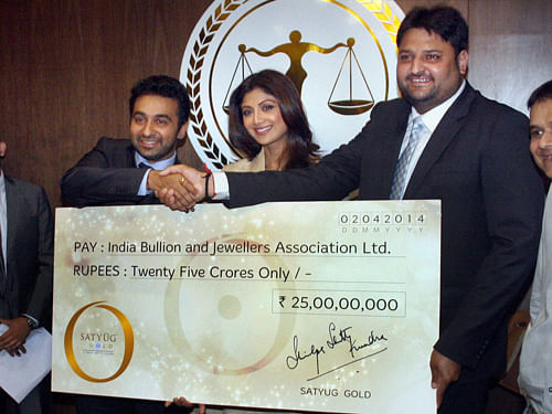 Mumbai: Indian Businessman, Raj Kundra along with wife and Bollywood actress Shilpa Shetty offer a cheque of 25 crores to Mohit Kamboj, President of Indian Bullion and Jewellers Association during the launch of their company, Satyug Gold in Mumbai on Wednesday. PTI Photo by Mitesh Bhuvad