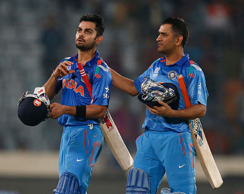Mahendra Singh Dhoni pats teammate Virat Kohli after their win over South Africa in the ICC Twenty20 Cricket World Cup semi-final match in Dhaka, Bangladesh, Friday, April 4, 2014. India won the match by six wickets. AP