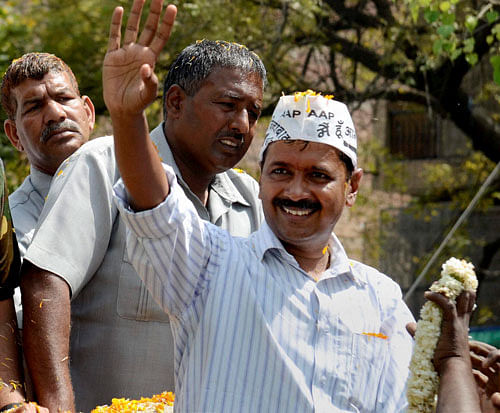AAP convener Arvind Kejriwal waves to supporters during his election road show at Dakshinpuri in New Delhi on Friday. PTI Photo