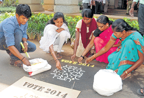 Women draw rangoli to create awareness on the importance of voting at an event organised by the BBMP in the City on Friday. dh photo