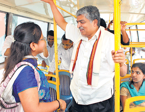 Bangalore South Congress candidate Nandan Nilekani interact with passengers in BMTC buses during their campaign in the City on Friday. DH photo