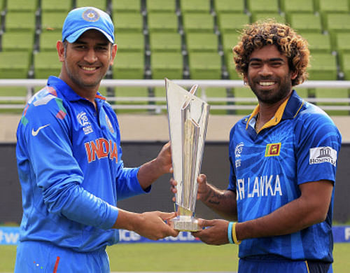 India's captain M.S Dhoni (L) and Sri Lanka's Lasith Malinga pose with the trophy of ICC Twenty20 World Cup at the Sher-E-Bangla National Cricket Stadium in Dhaka April 5, 2014. Sri Lanka and India will play in the final on Sunday. REUTERS