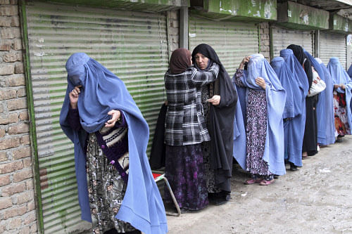 An Afghan woman searches voters before they enter a polling station to cast their ballots, in Kabul, Afghanistan, Saturday, April 5, 2014. Afghan voters lined up for blocks at polling stations nationwide on Saturday, defying a threat of violence by the Taliban to cast ballots in what promises to be the nation's first democratic transfer of power. AP Photo