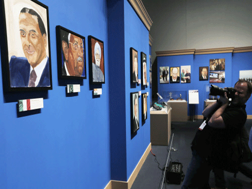 A member of the media photographs portraits of world leaders painted by former U.S. President George W. Bush, on display during 'The Art of Leadership: A President's Personal Diplomacy' exhibit at the George W. Bush Presidential Library and Museum in Dallas, Reuters photo