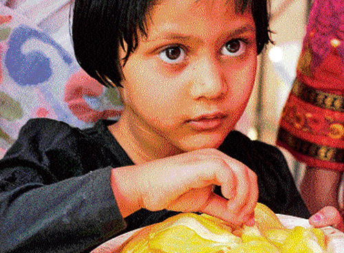 A girl tastes jackfruit at the Halasina Habba in the City on Sunday. dh photo