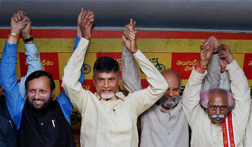 Hyderabad: BJP leader Prakash Javadekar join hands with TDP supremo Chandrababu Naidu with other TDP legislators after the two paties aanounced an alliance for the Lok Sabha polls in Hyderabad on Sunday. PTI Photo