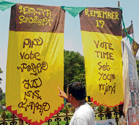 A man looks at banners displayed as part of 'Naanu Vote Madtini - Vote Spot,' a voter awareness campaign for the upcoming Lok Sabha elections, jointly organised by the BBMP and 'Srushti Ventures' in the City on Monday.  dh Photo